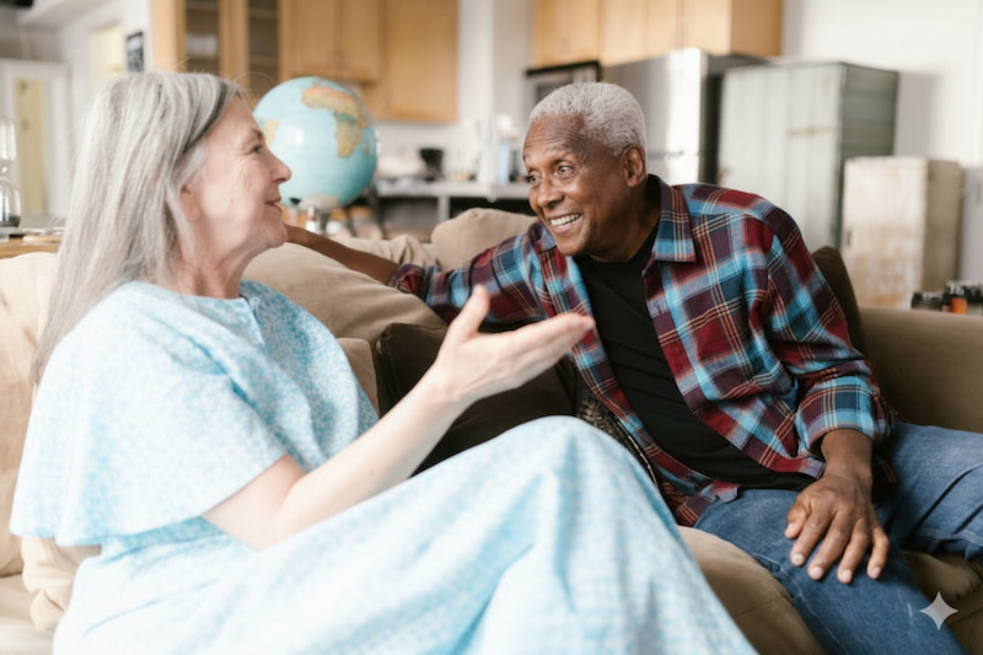 Joyful elderly couple sharing a warm moment at home, smiling and talking.